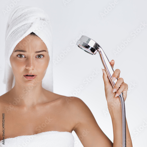 Perplexed Woman with Towel Turban Holding Shower Head During Water Shortage in photo