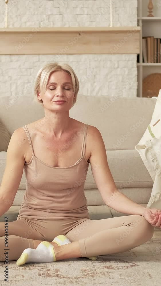 Vertical video. Breathing meditation. Harmony morning. Peaceful relaxed woman sitting in lotus pose on floor enjoying nirvana in light home interior. Vertical video. Breathing meditation. Harmony morning. Peaceful relaxed woman sitting in lotus pose on floor enjoying nirvana in light home interior.