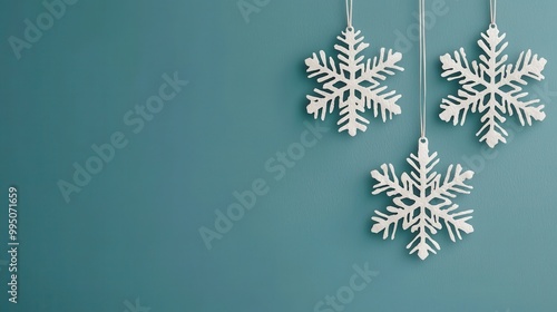 Wallpaper Mural Three elegant snowflakes hung beautifully against a calming teal background, perfect for winter-themed decor and celebrations. Torontodigital.ca
