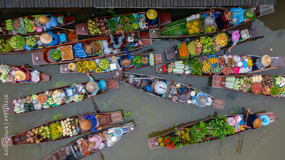 Fototapeta premium Aerial view Damnoen Saduak floating market, Farmer go to sell organic product, fruit, vegetable and Thai cuisine, Tourist visiting by boat, Ratchaburi, Thailand, Famous floating market in Thailand.