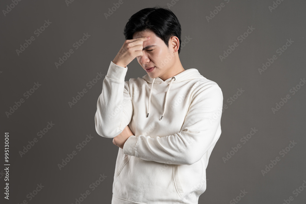 Portrait of Asian man wearing hoodie and posing on gray background. Portrait of Asian man wearing hoodie and posing on gray background.