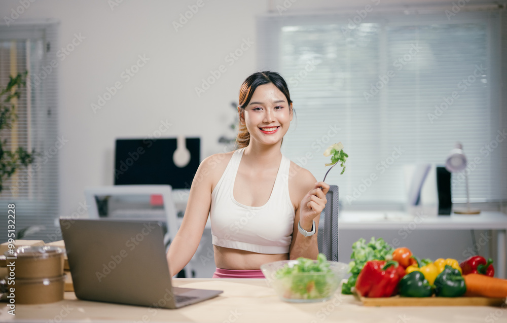 Young businesswoman is enjoying a healthy salad while working from home. She is taking a break from her work to nourish her body with fresh vegetables Young businesswoman is enjoying a healthy salad while working from home. She is taking a break from her work to nourish her body with fresh vegetables