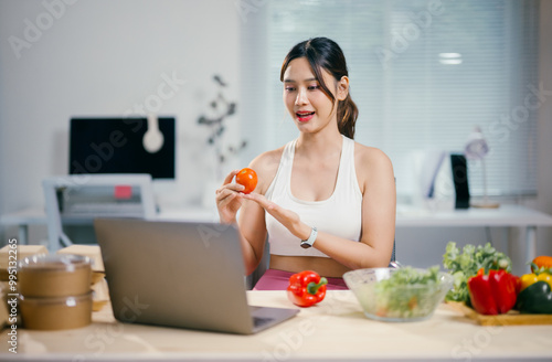 Nutritionist is holding a tomato while having an online consultation about healthy food and showing fresh vegetables to the camera