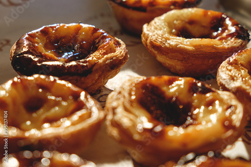 Fresh baked Pastel de nata or Pastel de belém .The most famous sweet in Portugal. Tart on baking sheet/