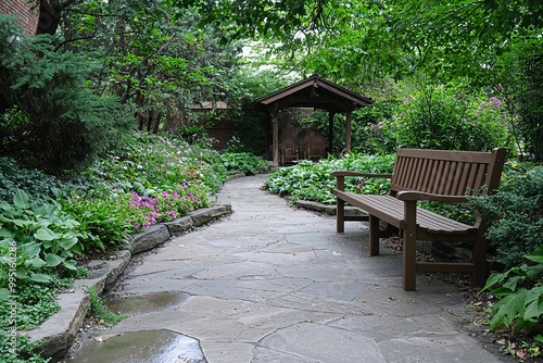 A serene corner of the garden with benches for relaxation. The peaceful spot invites community members to enjoy nature