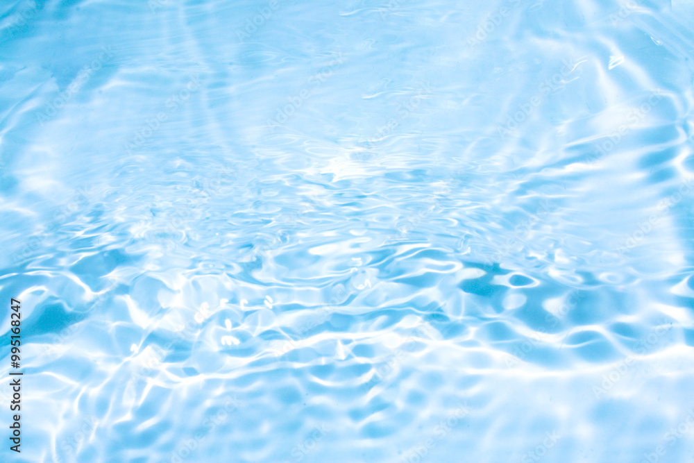 Blue water with ripples on the surface. Defocus blurred transparent blue colored clear calm water surface texture with splashes and bubbles. Water waves with shining pattern texture background. Blue water with ripples on the surface. Defocus blurred transparent blue colored clear calm water surface texture with splashes and bubbles. Water waves with shining pattern texture background.