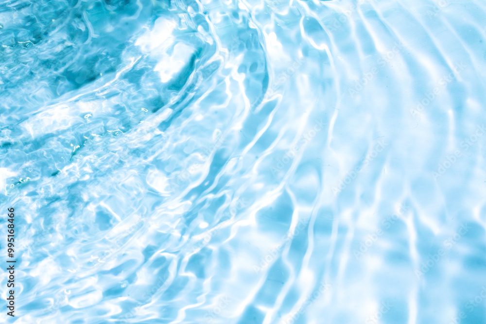 Obraz premium Blue water with ripples on the surface. Defocus blurred transparent blue colored clear calm water surface texture with splashes and bubbles. Water waves with shining pattern texture background.