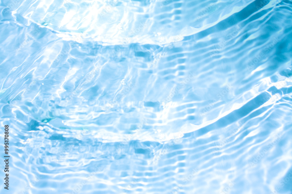 Obraz premium Blue water with ripples on the surface. Defocus blurred transparent blue colored clear calm water surface texture with splashes and bubbles. Water waves with shining pattern texture background.