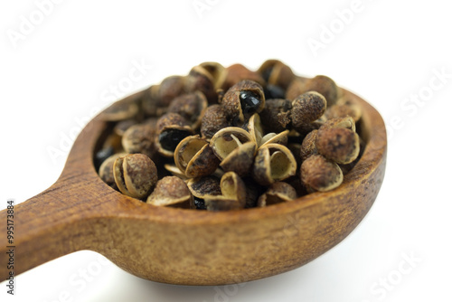 Makhwaen , Zanthoxylum limonella (Dennst.) Alston., is northern Thai spices, dried seeds used for cooking, in brown wooden spoon isolated on white background with clipping path, closed up. Copy space. photo