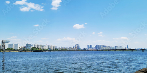 panorama view of the river, Yeouido Hangang River Park, in Seoul, Korea, with a broad bridge, and a cityscape in the backdrop 