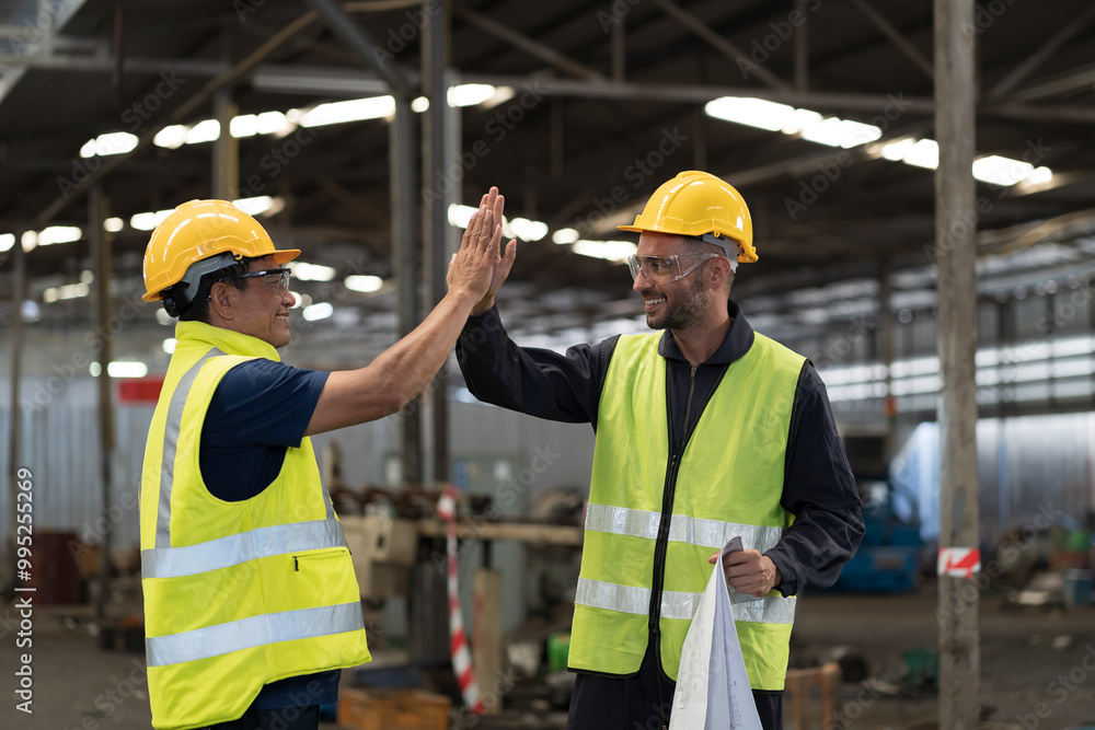 Two male engineer join hands together in industry factory. Finished, completed work concept Two male engineer join hands together in industry factory. Finished, completed work concept
