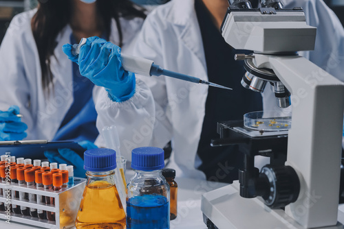 Scientist using microscope in laboratory. Close-up of a researcher's hands adjusting a modern microscope in a lab setting. Science concept