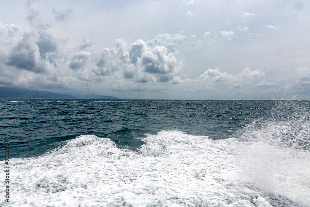 Fototapeta premium Small city near Portofino from the sea with dramatic sky