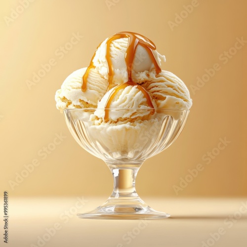 Creamy vanilla ice cream scoops drizzled with caramel sauce in a elegant glass bowl on a soft golden background.