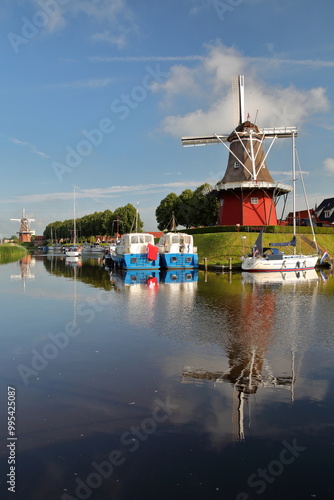 Reflections of windmills and boats on canals (Baantjegracht) in Dokkum, Friesland, Netherlands photo