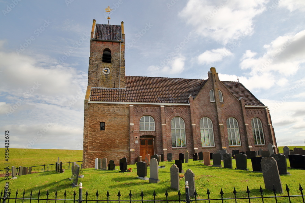 The reformed St Mary's church (Mariatsjerke) alongside the sea shore (Wadden Sea) in the terp village Wierum, Friesland, Netherlands