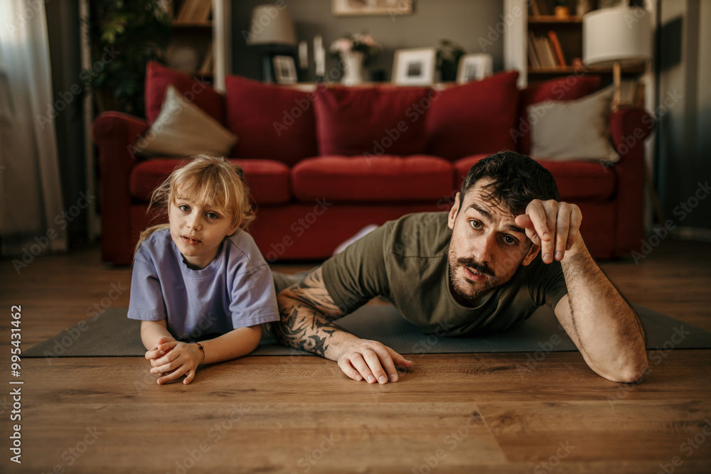 Cheerful father and his daughter having a great workout in their living room. Cheerful father and his daughter having a great workout in their living room.