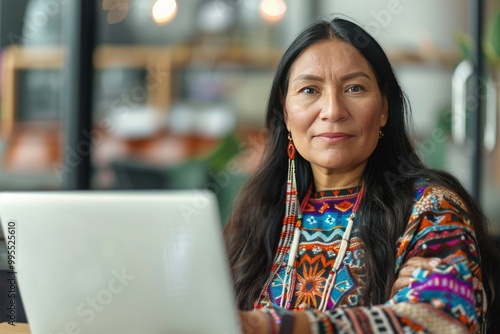 Professional Indigenous female employee or businesswoman using a laptop in a modern office. Copy space. , background blur