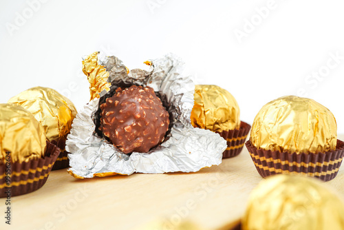Sweet chocolate balls is made. Chocolate candy in gold wrapper on white background