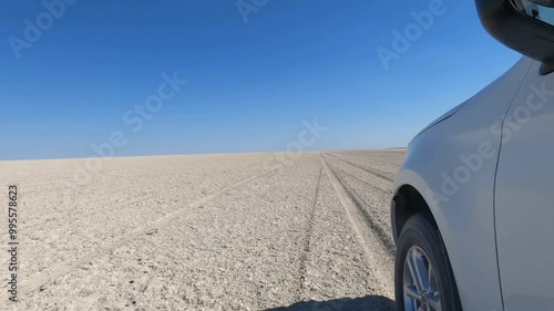 Seitlicher Blick auf ein Auto, das über eine Salzpfanne in Botswana fährt