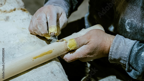 carpenter using nail gun or brad nailer tool on wood box in a workshop ,furniture restoration woodworking concept. selective focus photo