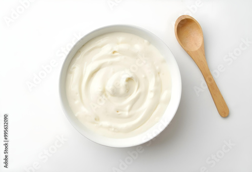 Creamy yogurt in white bowl on clean background, accompanied by wooden spoon, evokes sense of freshness and simplicity. Perfect for healthy eating or culinary inspiration