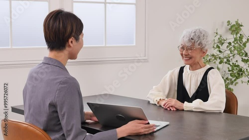 保険の営業の女性と話す高齢者の女性