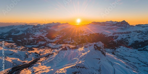 Aerial View of the Swiss Alps at Sunrise in Winter with Snowy Trails