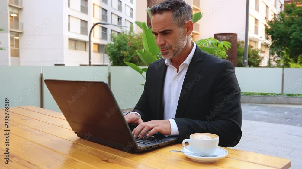 Side view Businessman working on his laptop outdoors. Side view Businessman working on his laptop outdoors.