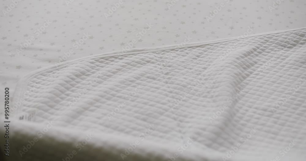 Modern empty wooden crib with mattress, cotton sheet and blanket in nursery room. Wooden crib with mattress, cotton sheet and blanket in nursery room. Expecting newborn and prepare kids room.