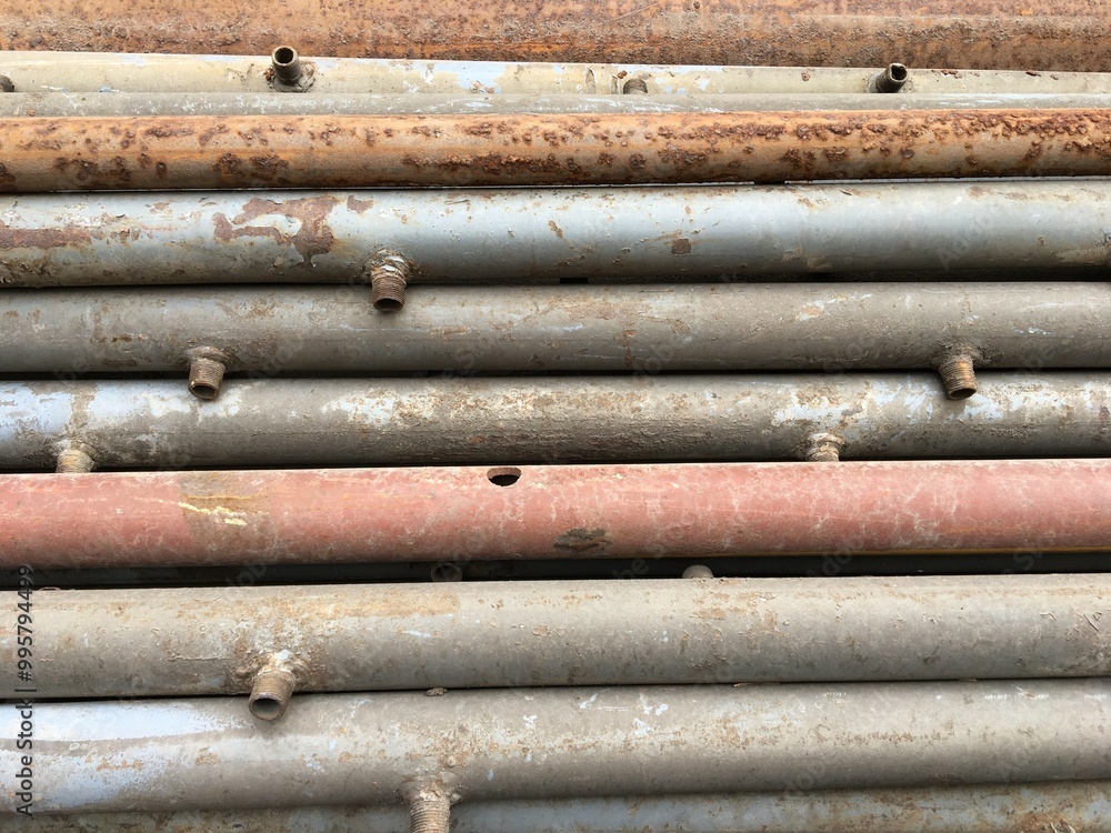 Rusty old metal pipes lie in a row. Scrap metal. Metal background Rusty old metal pipes lie in a row. Scrap metal. Metal background