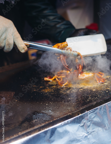 Korean Spicy Grilled Squid, Ojingeo tonggui, grilled octopus tentacles, variety of different street food selection in Seoul, South Korea, night market with local vendor stalls cooking tasty dishes photo