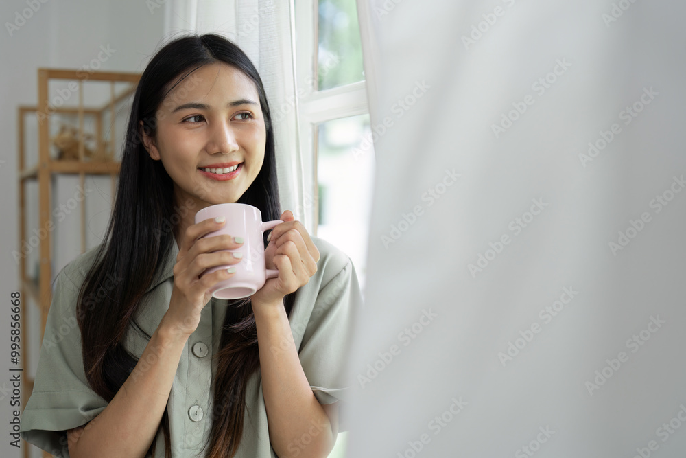 Young Woman Enjoying Morning Coffee by the Window in a Cozy Home Setting Young Woman Enjoying Morning Coffee by the Window in a Cozy Home Setting