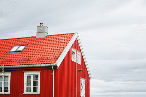 Vibrant red house with orange roof and skylight window