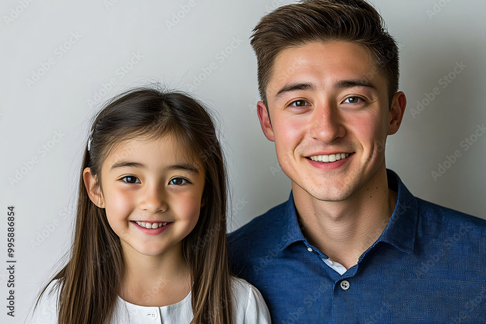 Mixed racial Father and cute daughter smiling and interacting in front of a plain background, dressed in simple clothes, captured in a family photo portrait shoot showcasing their joyful bond Mixed racial Father and cute daughter smiling and interacting in front of a plain background, dressed in simple clothes, captured in a family photo portrait shoot showcasing their joyful bond