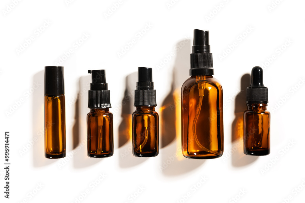 Amber glass bottles for cosmetics, natural medicine or essential oils isolated on a white background Amber glass bottles for cosmetics, natural medicine or essential oils isolated on a white background