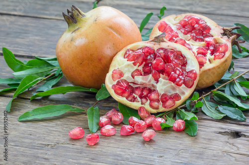 pomegranate and raw pomegranates on a wooden background