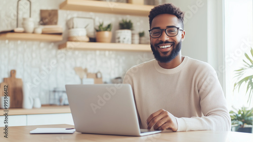 Smiling young professional at a kitchen counter turned workspace, engaged in a virtual meeting, bright morning light, remote work, virtual meeting, home office setup