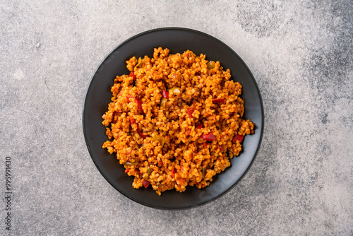 Schilderij op canvas Turkish traditional food tomato bulgur pilaf on black stone table