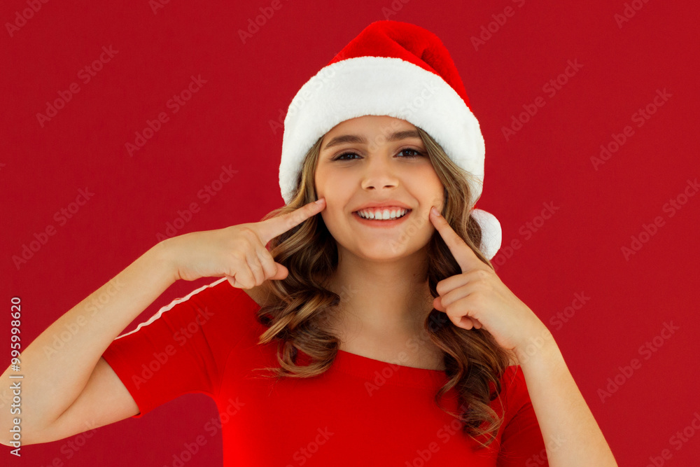 Photo of pretty young girl fingers press cheeks smiling wears christmas sweater isolated on red color background Photo of pretty young girl fingers press cheeks smiling wears christmas sweater isolated on red color background