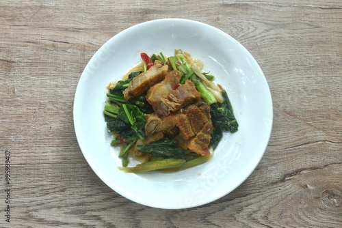 fried Chinese kale and cabbage with crispy pork in soy sauce on plate 