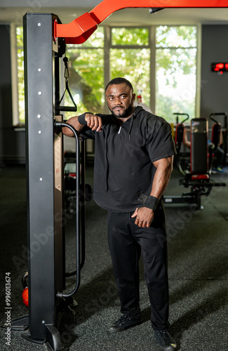 Young man posing confidently in a fitness gym.