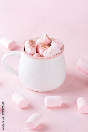 Cup of hot cocoa drink with marshmallows on pink background. Vegan, sugar and lactose free. Vertical orientation.