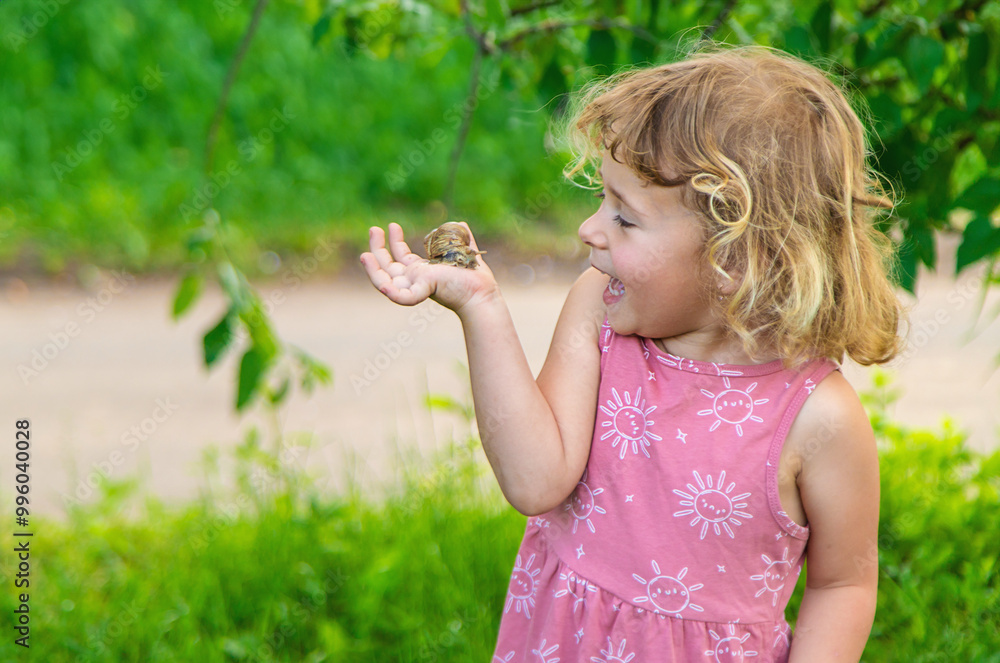 Child holding a snail on his hand. Selective focus. Child holding a snail on his hand. Selective focus.