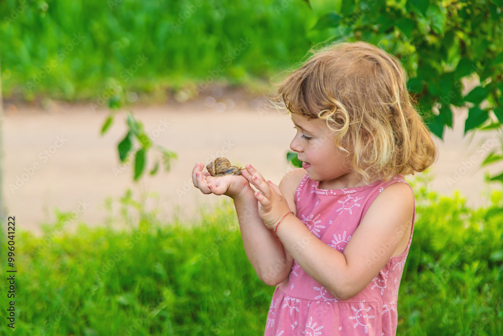 Child holding a snail on his hand. Selective focus. Child holding a snail on his hand. Selective focus.