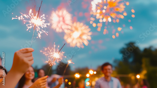 A vibrant Diwali celebration under the night sky, where families are gathered in a garden lighting sparklers while fireworks burst overhead in brilliant colors. The soft glow from photo