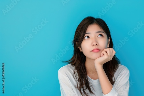 Woman Wondering. Portrait of Asian Fashionable Woman Thinking in Blue Attire