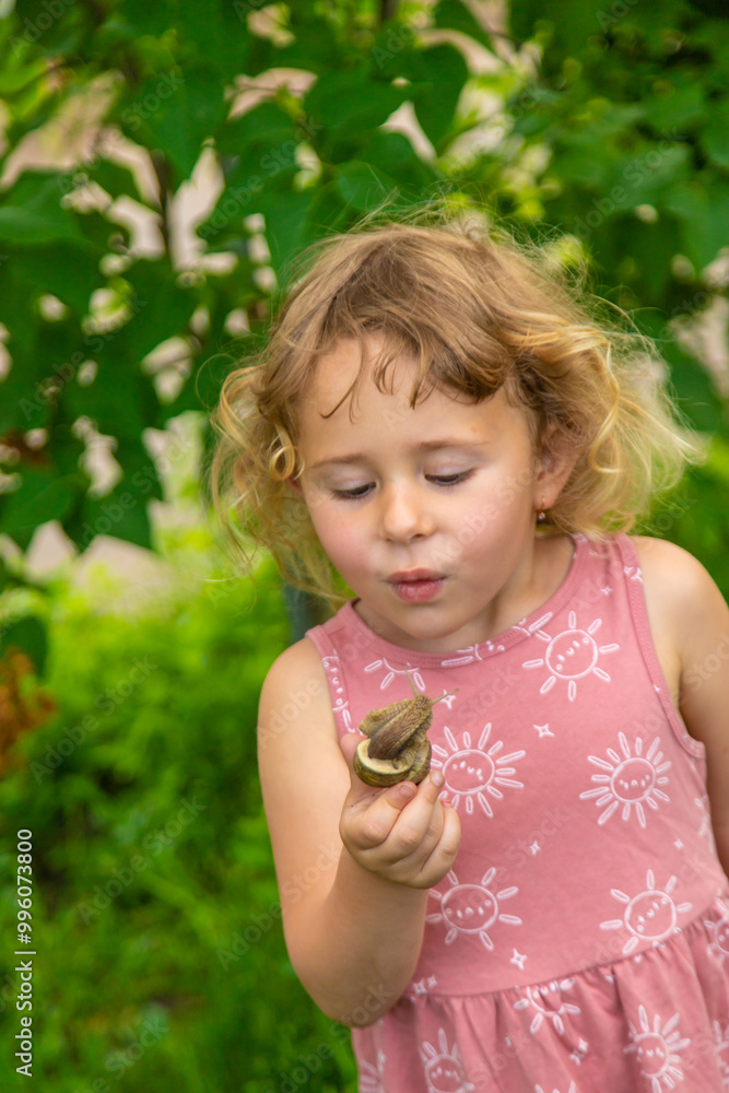 Child holding a snail on his hand. Selective focus. Child holding a snail on his hand. Selective focus.