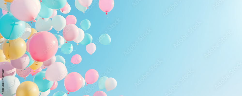 Pink and blue balloons floating in a clear sky during a celebration or festive event, background with copy-space Pink and blue balloons floating in a clear sky during a celebration or festive event, background with copy-space