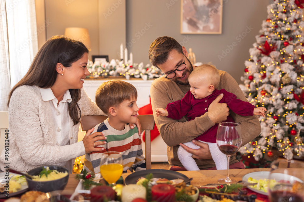 Young parents having Christmas dinner with children at home Young parents having Christmas dinner with children at home